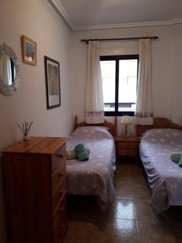 1 dormitorio con 2 camas individuales y ventana en Playa Marina Phase II, en Cabo Roig