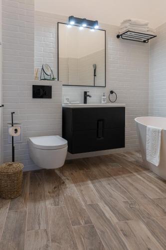 un bagno con un lavandino, una vasca e uno specchio di Olympic Boutique a Constanţa
