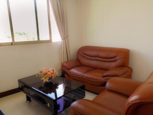 a living room with a leather chair and a coffee table at Evergreen Hotel in Antananarivo