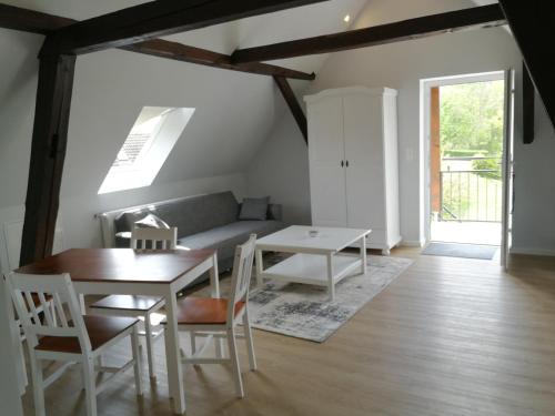 a living room with a table and a couch at Pension Schlossblick Thallwitz in Thallwitz