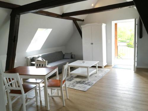 a living room with a table and a couch at Pension Schlossblick Thallwitz in Thallwitz