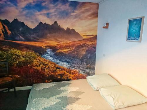 a bedroom with a painting on the wall at Hôtel Restaurant L Orée du Vercors in Montmaur-en-Diois