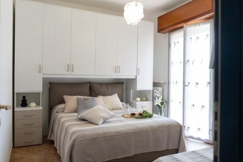 a bedroom with a large bed with white cabinets at [V.LE DELLA REPUBBLICA] Bilocale vicino al mare. in Pietra Ligure