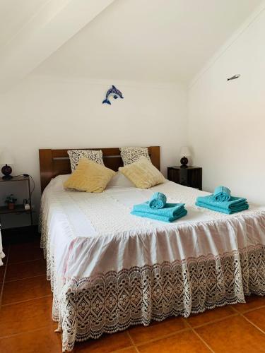 a bedroom with a bed with two towels on it at Casas da Bela - Bairro Típico na Nazaré in Nazaré