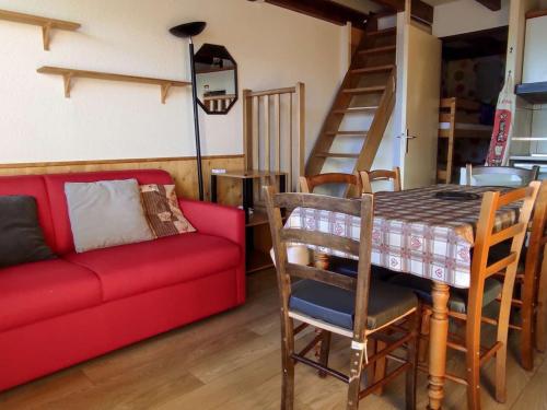un salon avec un canapé rouge et une table dans l'établissement Studio cabine mezzanine avec box voiture et parking, ascenseur panoramique - FR-1-580-26, à Font-Romeu-Odeillo-Via