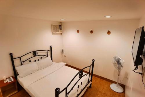 um quarto com uma cama preta e uma ventoinha em Marion Hotel em Manila