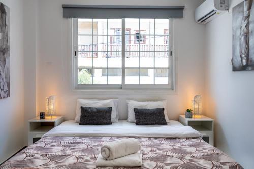 a bedroom with a large bed with a window at Mila's 1-BR Apartment in Larnaca in Larnaka