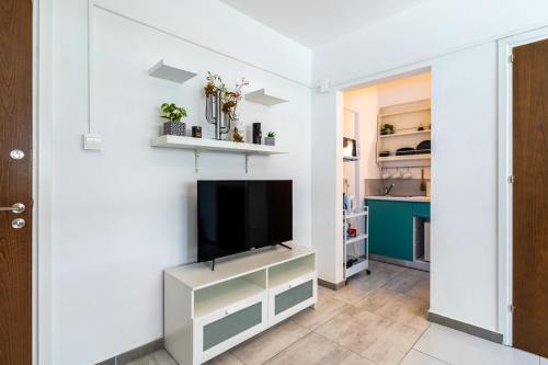 a living room with a flat screen tv on a wall at Mila's 1-BR Apartment in Larnaca in Larnaka
