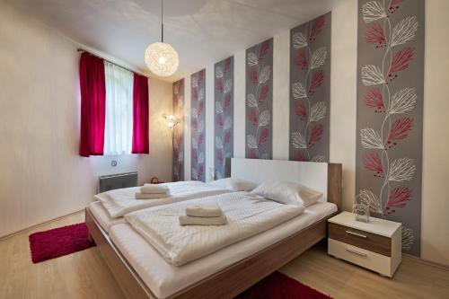 een slaapkamer met een groot wit bed en een rood tapijt bij Apartment Bonita Tále in Bystrá