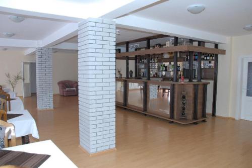 a room with a white brick pillar and a bar at Guesthouse Vila Nova in Morović