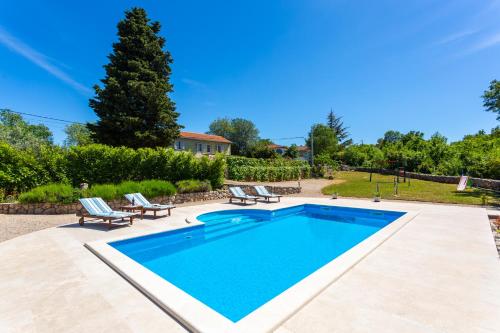 a swimming pool with two lounge chairs next to at Villa Katarina in Rasopasno