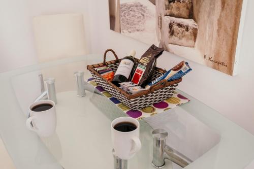 a basket on a counter with two cups of coffee at Adelphi Apartments in Perissa