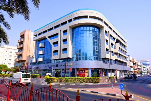 a large building with glass windows on a city street at ABJAD CROWN HOTEL in Dubai