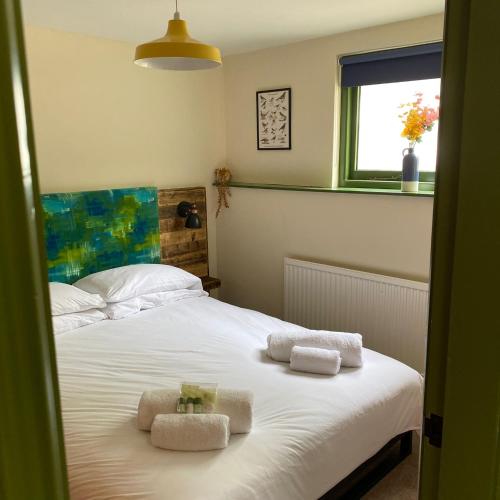 - une chambre avec un lit et des serviettes dans l'établissement The Bolthole @ Bowness - Cosy 1 Bed Apartment, à Bowness-on-Windermere