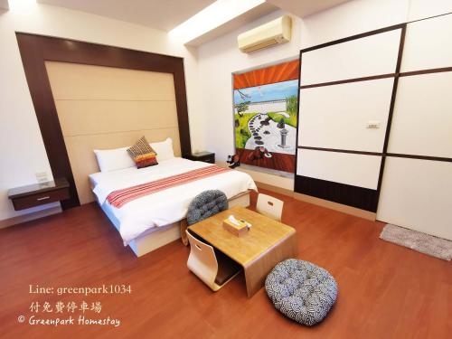 a hotel room with a bed and a table at Green Park Homestay in Luodong