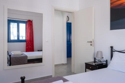 a bedroom with a bed and a mirror at Adelphi Apartments in Perissa