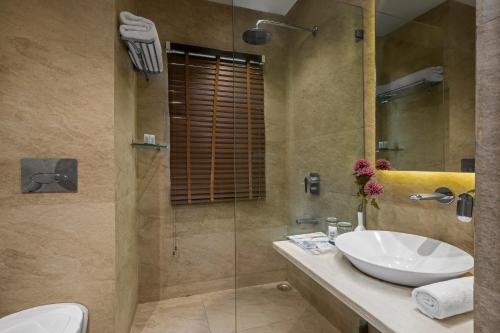 y baño con lavabo y ducha. en The Manor Kashipur by Leisure Hotels, en Kāshīpur