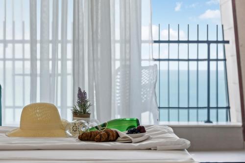 een hoed en een fruitschaal op een tafel met een raam bij Nympha Hotel, Riviera Holiday Club - All Inclusive & Private Beach in Goudstrand