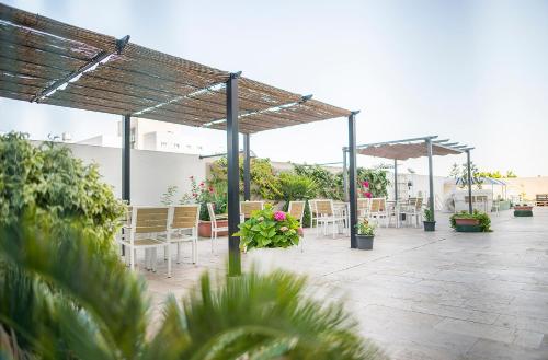 a patio with chairs and tables and umbrellas at Hotel Xon's Valencia in Aldaya