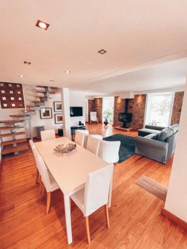 a dining room and living room with a table and chairs at Casa da Aldeia in Constância