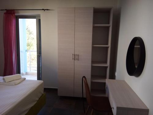 a bedroom with a desk and a bed and a mirror at Armonia Studios Preveza in Preveza