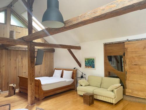 een slaapkamer met een bed en een bank erin bij Bavaria Cottage mit Casetta oder Chalet in Tegernheim bei Regensburg in Tegernheim