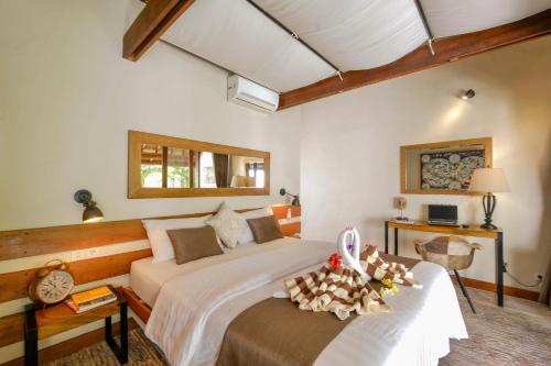 1 dormitorio con cama, mesa y espejo en Motu, en Gili Trawangan