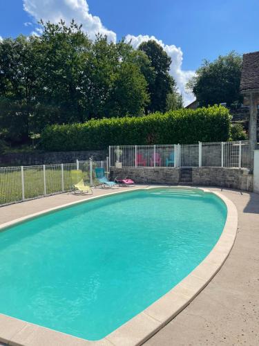 une grande piscine bleue dans une cour dans l'établissement Le CLOS DE L AMANDIER, à Château-Chalon