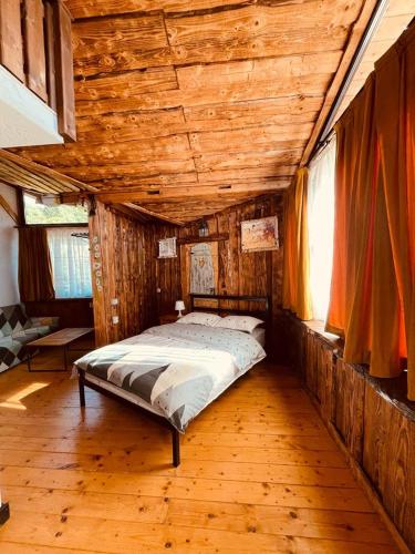 a bed in a room with a wooden ceiling at Cabana Vanatorului 8 in Râşnov