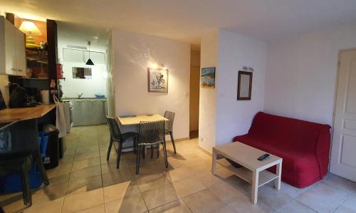 un salon avec un canapé rouge et une table dans l'établissement Appartement avec vaste terrasse à 30 m des dunes, au Cap d'Agde