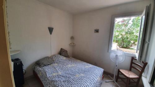 une petite chambre avec un lit et une fenêtre dans l'établissement Appartement avec vaste terrasse à 30 m des dunes, au Cap d'Agde