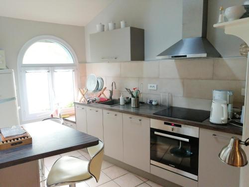 a kitchen with white cabinets and a stove top oven at Maison charmante à Sisteron avec terrasse et jardin in Sisteron