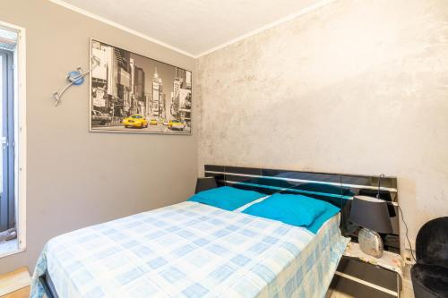 een slaapkamer met een bed met een blauw dekbed bij La Maximoise in Sainte-Maxime