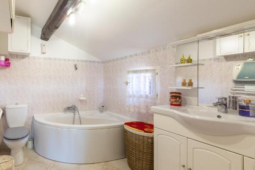 een badkamer met een bad, een toilet en een wastafel bij La Maximoise in Sainte-Maxime