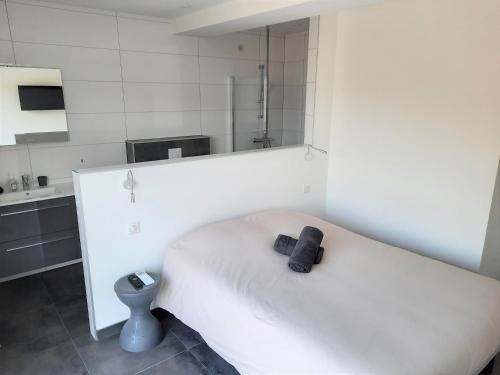 a bedroom with a white bed with a black towel on it at Villa Cupabia vue mer in Viggianello