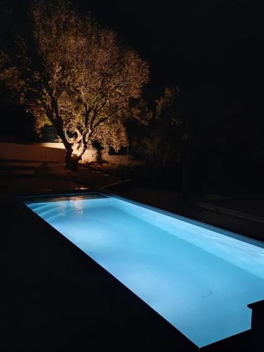 a swimming pool lit up at night at Villa Cupabia vue mer in Viggianello