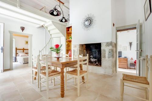 une salle à manger avec une table et une cheminée dans l'établissement La Bastide de Larrouy, à Fieux