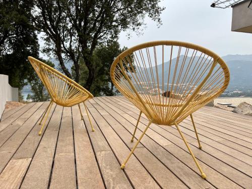 two chairs sitting on top of a wooden deck at Villa Cupabia vue mer in Viggianello