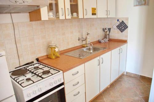 kuchnia z kuchenką i zlewem w obiekcie Two bedroom apartments Elvira w Novalji