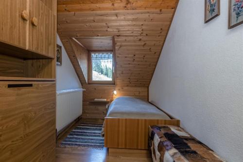 a small room with a bed and a window at Almhütten Sonnblick & Almfried in Sonnenalpe Nassfeld