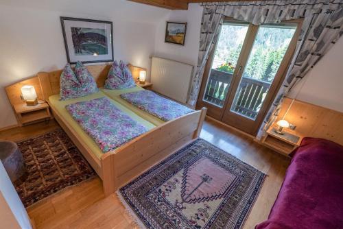 a bedroom with two beds and a large window at Almhütten Sonnblick & Almfried in Sonnenalpe Nassfeld