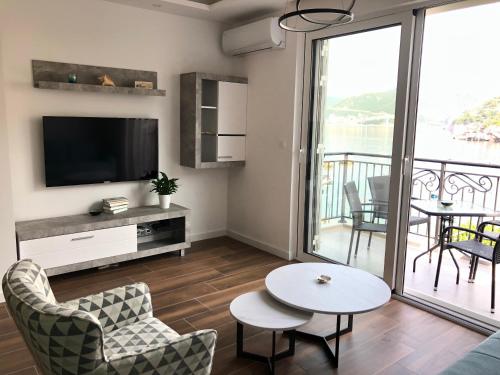 a living room with a television and a table and chairs at Apartment Sara with seaview in Budva