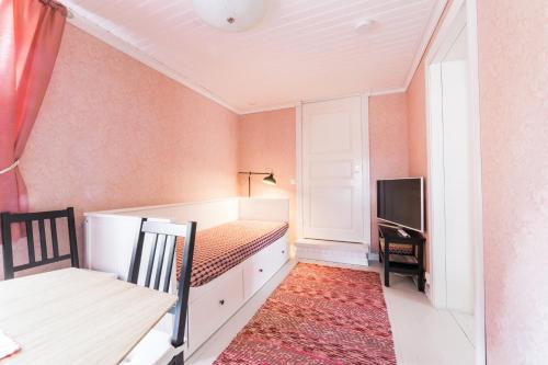 a bedroom with a bed and a desk and a television at Tiittalan Kartano in Sulkava
