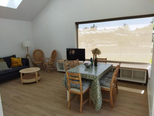 un salon avec une table, des chaises et un canapé dans l'établissement Les cabines du bout du monde Plain pied votre pied à terre breton haut standing, à Crozon
