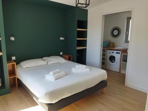 1 dormitorio con 1 cama con toallas en Les cabines du bout du monde Plain pied votre pied à terre breton haut standing, en Crozon