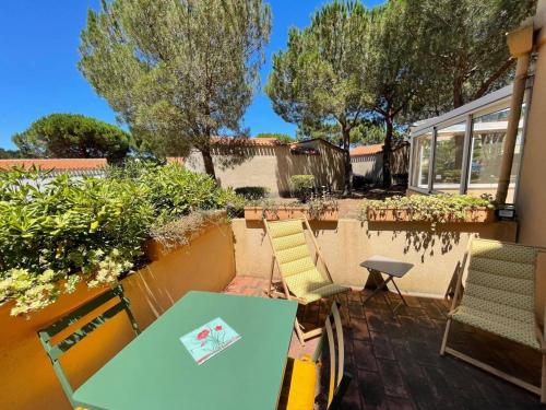 un patio avec une table, des chaises et des arbres dans l'établissement Studio cosy avec terrasse à 200m de la mer – Parking privé et calme, 2 pers, Argelès-sur-Mer - FR-1-225-692, à Argelès-sur-Mer