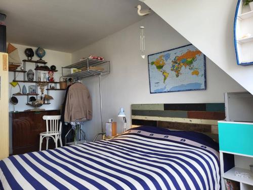 - une chambre avec un lit rayé bleu et blanc dans l'établissement Appartement Merville-Franceville-Plage, 2 pièces, 4 personnes - FR-1-465-62, à Merville-Franceville-Plage