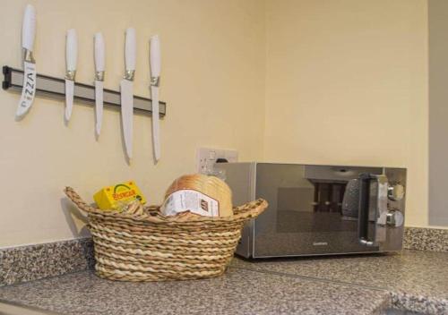 a basket on a counter next to a microwave at Cosy Cottage In Cardigan in Cardigan