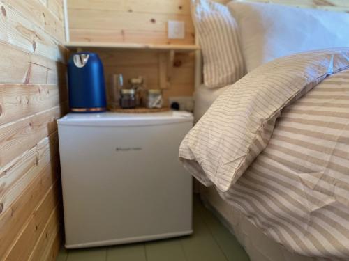 a small refrigerator next to a bed in a room at Hideaway at Hestercombe in Kingston