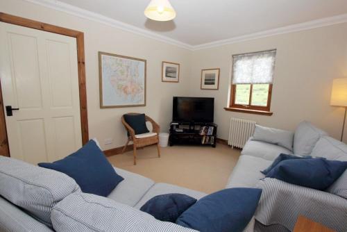 a living room with two couches and a tv at Saltwinds in Carbost